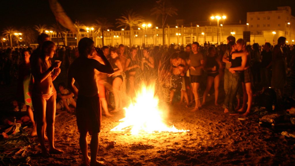 <em>Locals gather around bonfire in Valencia on San Juan. </em>